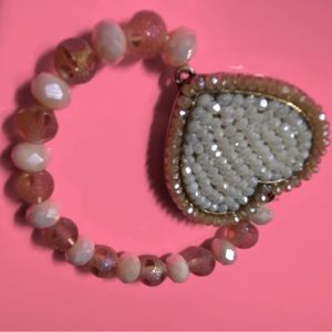 Bracelet soft pink beads and heart with white stones.